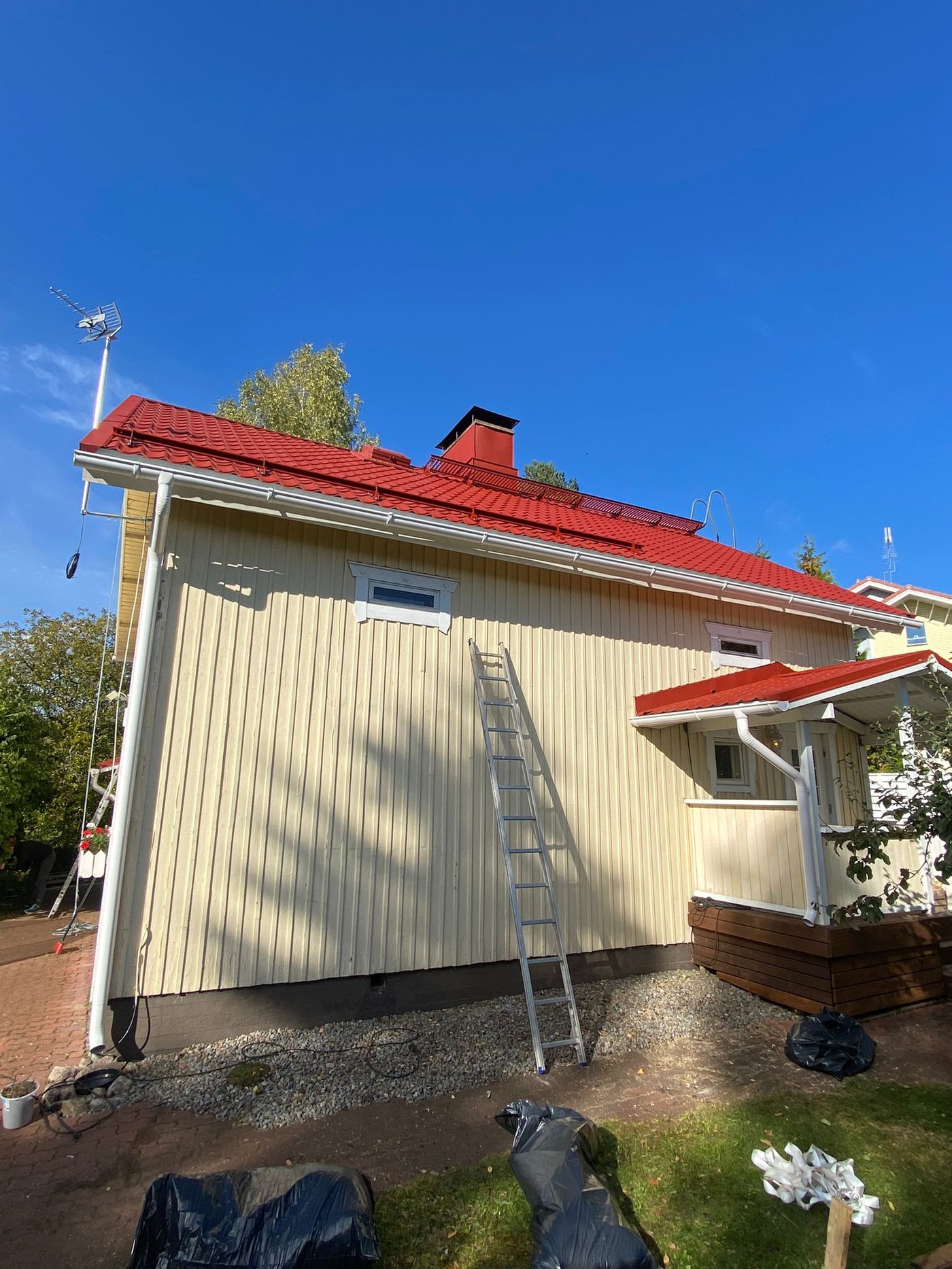Tumma peltikatto ja punaiset räystäät